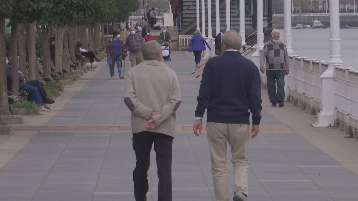 Dos personas mayores pasean por Bilbao. 