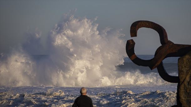 Un hombre en el Peine de los vientos de San Sebastián, ante grandes olas. 