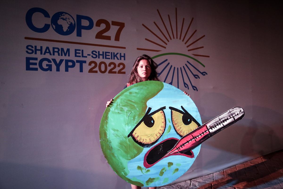 Una activista sostiene un cartel en la Cumbre del Clima de Sharm el Sheikh. Foto: EFE