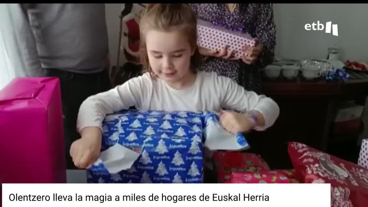 Una niña abre su regalo.