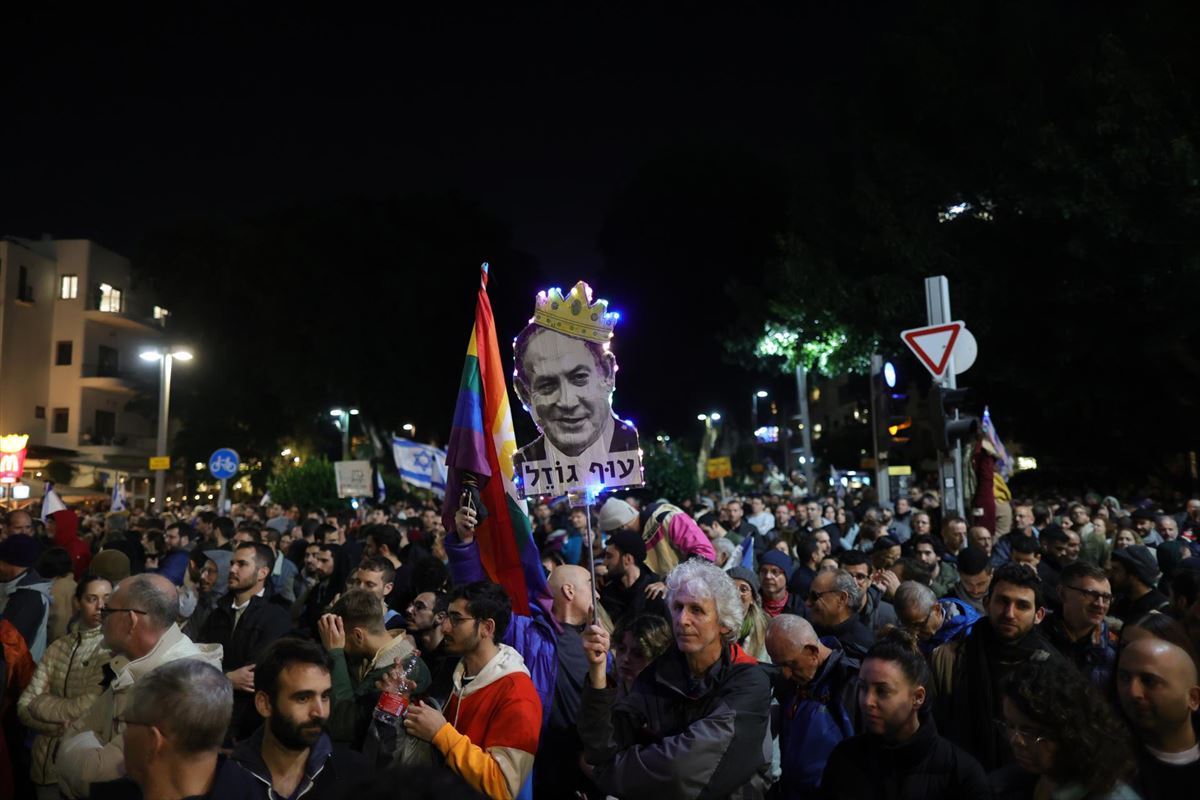 Manifestantes portan un retrato de Netanyahu, con corona. EFE.