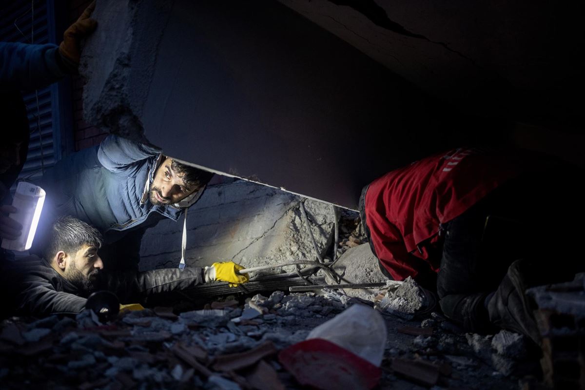 Varias personas tratan de ayudar en la oscuridad y bajo los escombros en Diyabakir (Turquía). Foto: EFE