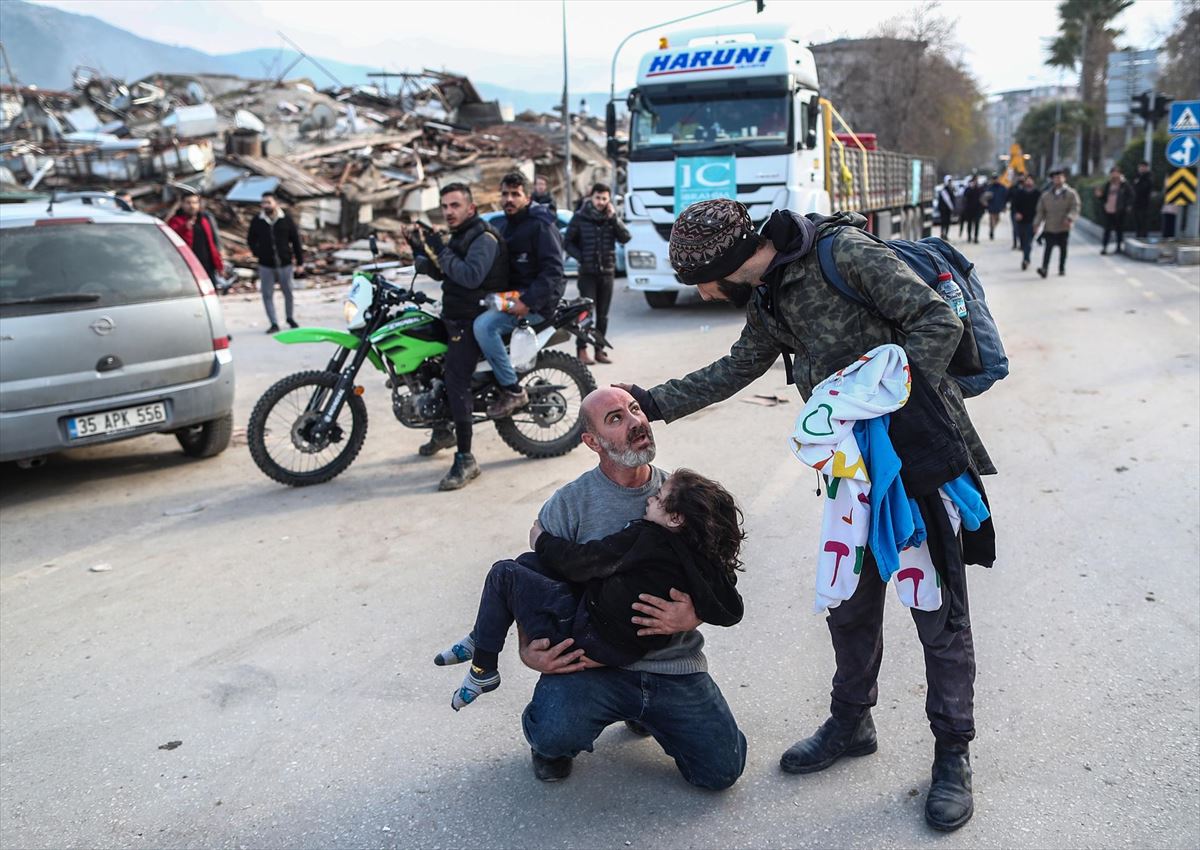 Un hombre con una menor en brazos en Hatay (Turquía). Foto: EFE