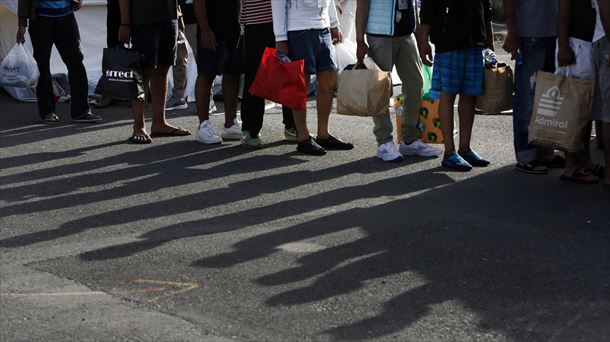 Supervivientes esperan al autobús que les llevará de Kalamata a un centro de recepción. EFE. 