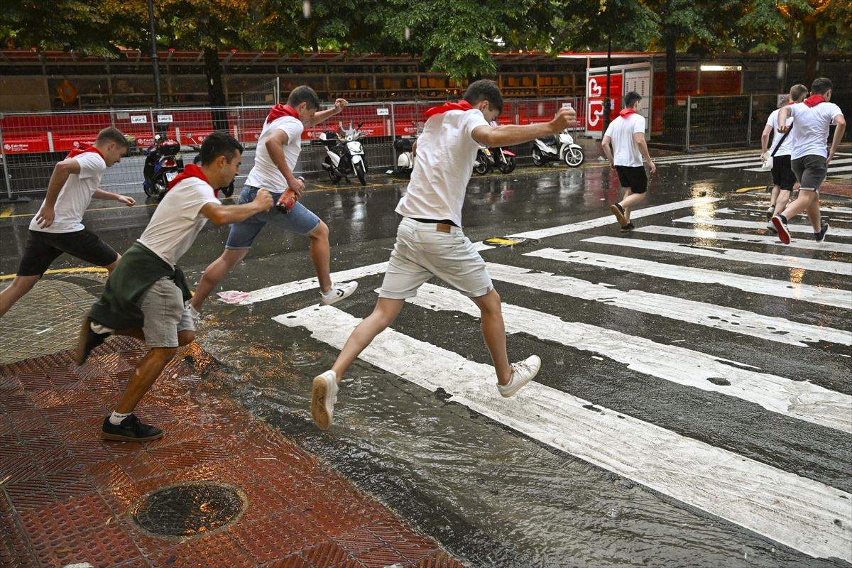 Jóvenes saltando charcos en Pamplona. Foto: EFE