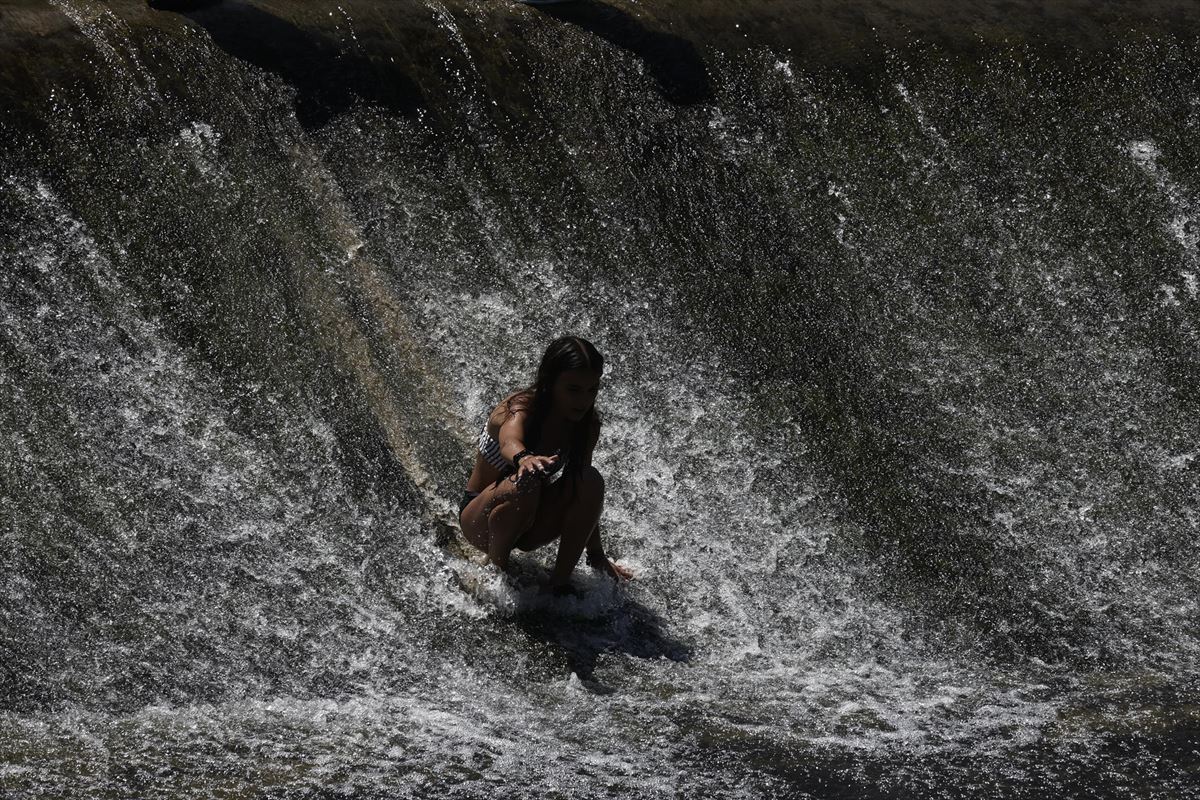 Una persona disfruta de un baño en el río Arga para intentar paliar el calor. Foto: EFE