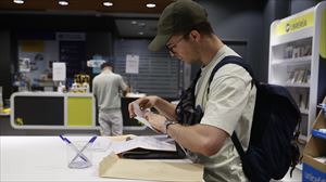 Un hombre depositando su voto en una oficina de Correos