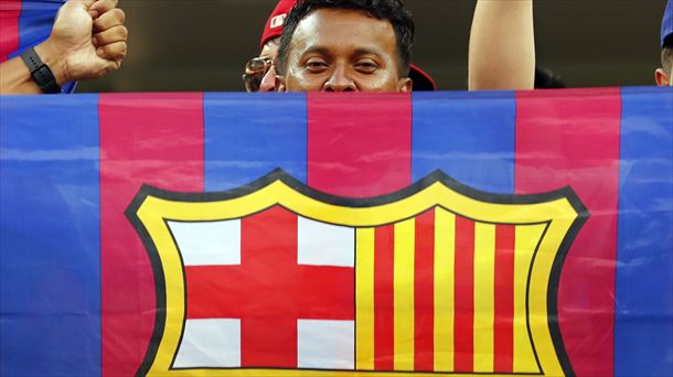 Aficionado del Barcelona con una bandera del equipo. Foto: EFE