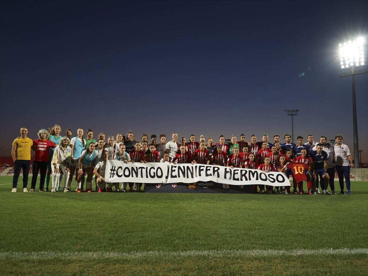 Jugadoras y demás personal técnico sostiene una pancarta de apoyo a Jennifer Hermoso. Foto: EFE