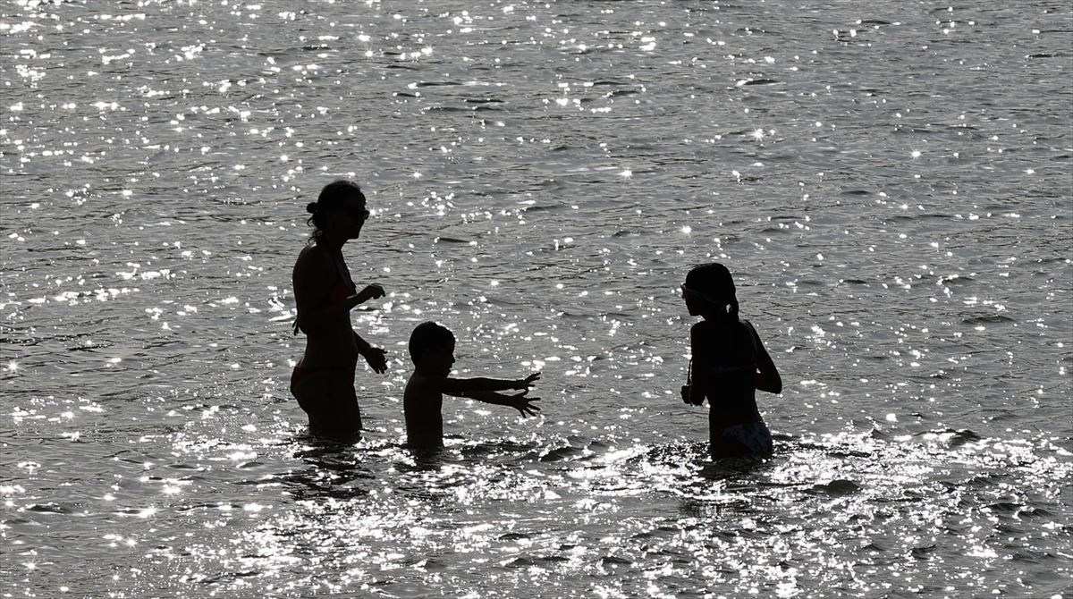 Tres personas tomándose un baño en una playa de Getxo
