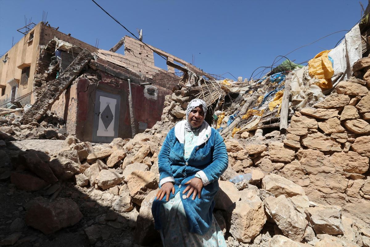 Una mujer, sentada sobre los escombros de su casa derruida, en Moulay Brahim. Foto: EFE