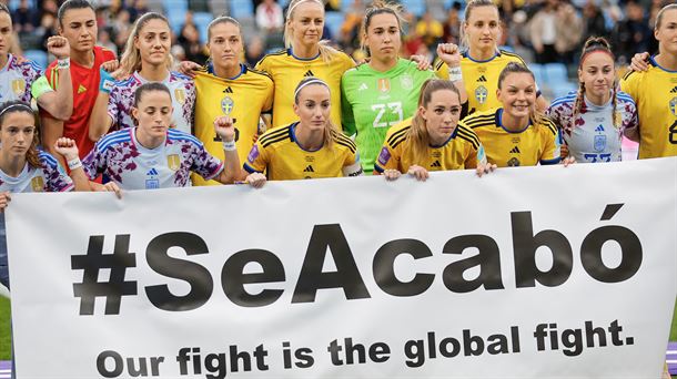 Jugadoras suecas y españolas con una pancarta. Foto: EFE.