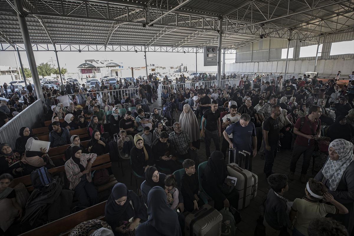 Cientos de personas esperan en el paso de Rafah. 