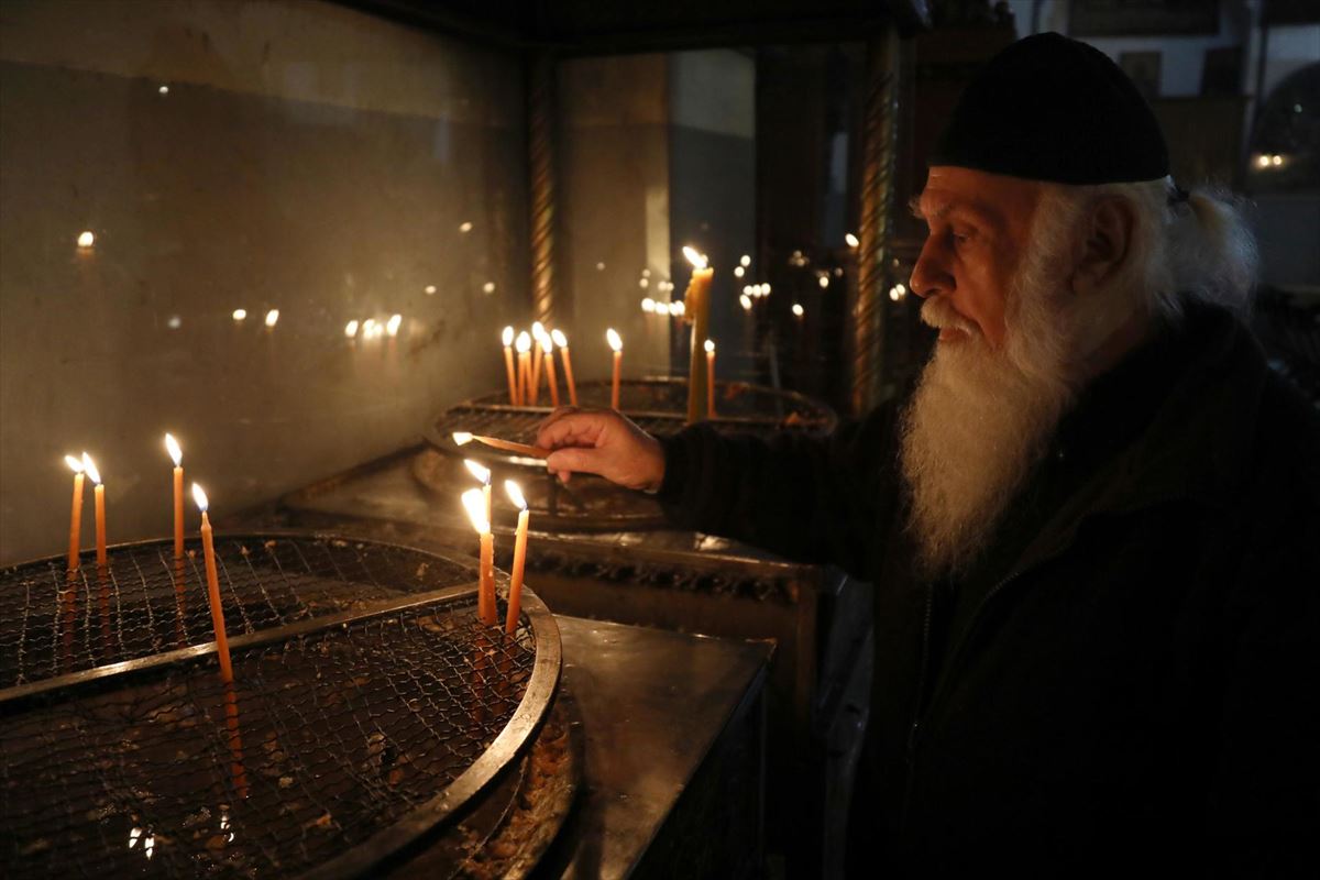 Un clérigo enciende velas en la Iglesia de la Natividad de Belén. EFE. 