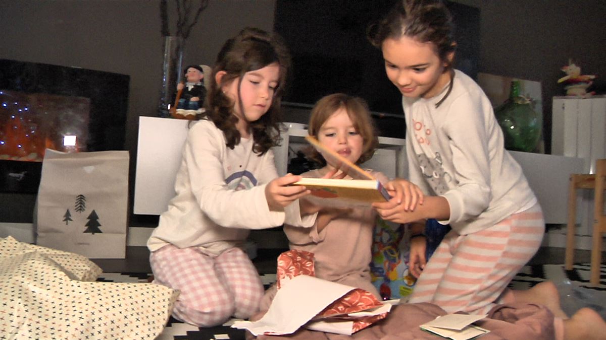 Tres niñas abriendo sus regalos.