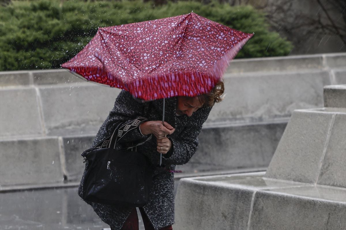 Una mujer sujetando un paraguas. Foto: EFE