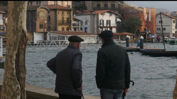 Dos hombres miran los efectos de la subida del mar en Pasai Donibane. Foto: EITB Media