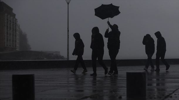 Varias personas bajo la lluvia en San Sebastián. 