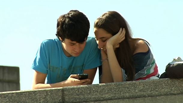 Dos jóvenes consultan por internet con el teléfono móvil. EITB