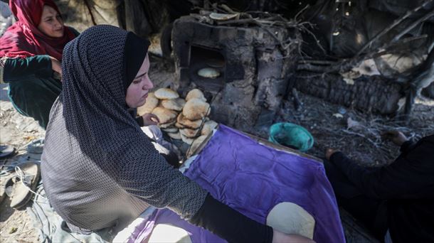 Mujeres asan pan en Gaza, en hornos improvisados entre escombros. EFE. 