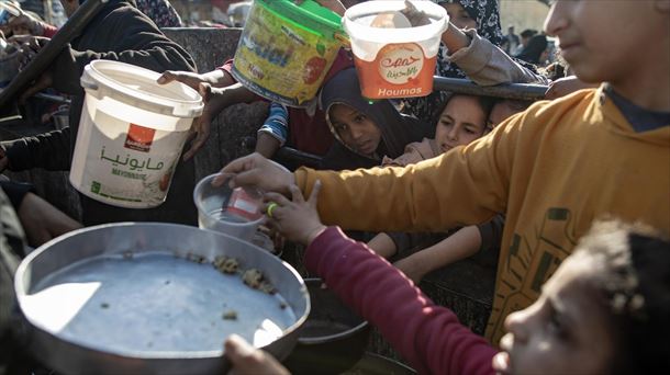 Niños y mayores reciben comida en la Franja de Gaza. Foto: EFE