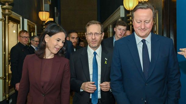 Annalena Baerbock (ezkerrean), Isaac Herzog (erdian) eta David Cameron (eskuinean).