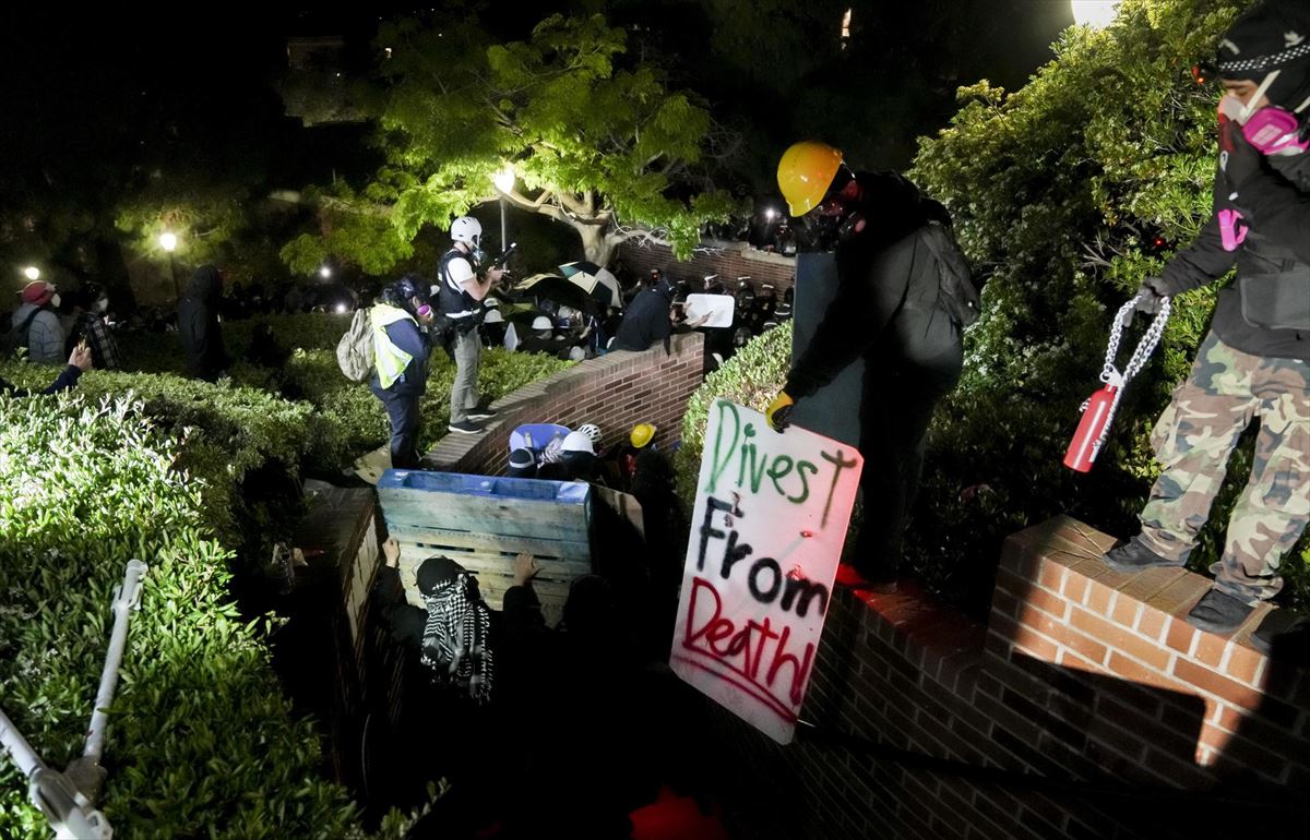 Agentes de Policía quitan una pancarta en el campus de la Universidad de California en Los Ángeles.