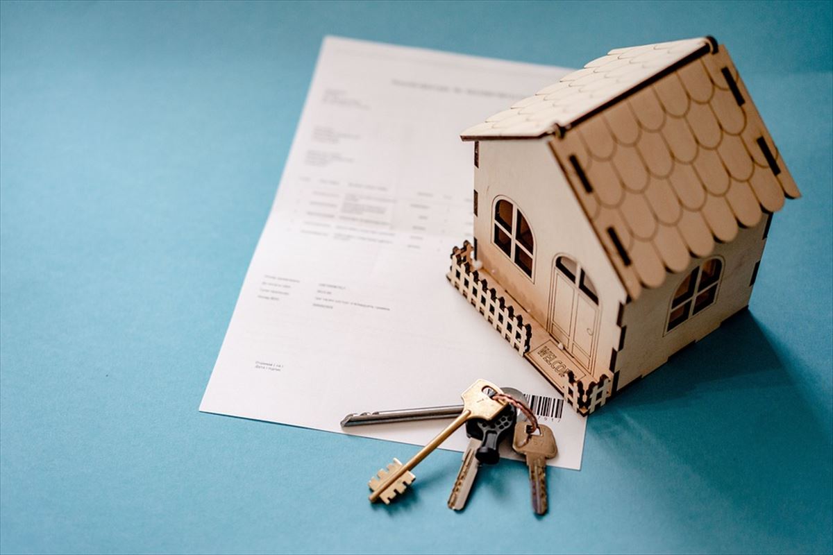 Representación de una vivienda con unas llaves y un papel firmado de hipoteca