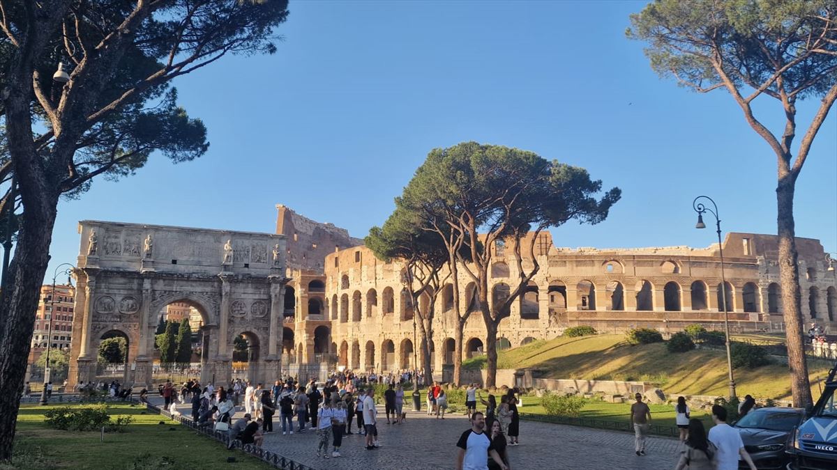 Turistas en Roma con el Coliseo de fondo