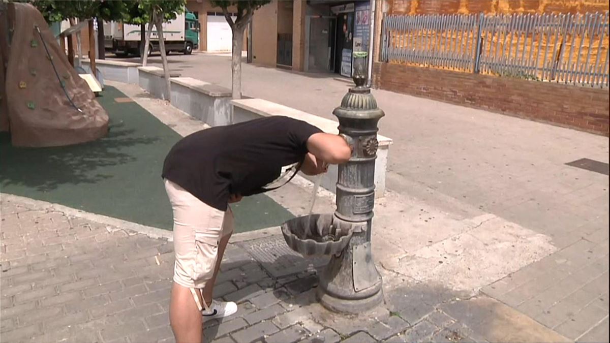 Hombre bebiendo agua de una fuente en Navarra.