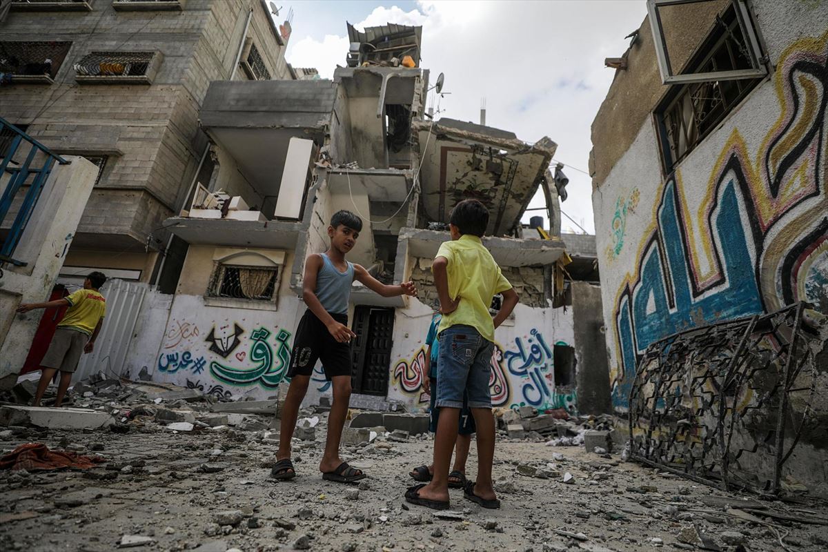 Dos niños, entre los escombros de sus casas, hoy, en Al Nusairat. EFE. 
