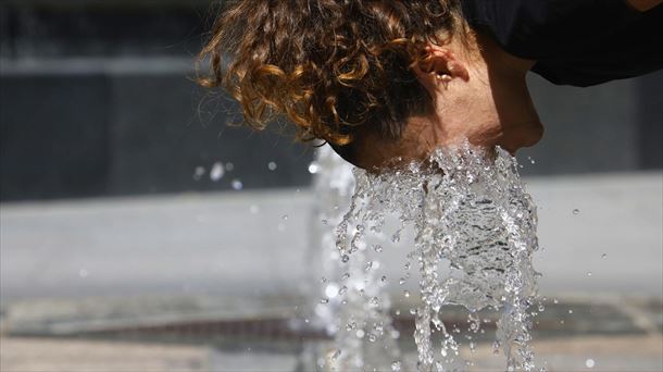 Una chica se refresca en una fuente. EFE. 