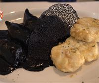 Txipirones rellenos en su tinta con merluza rebozada, plato estrella de La Ola, en Getxo