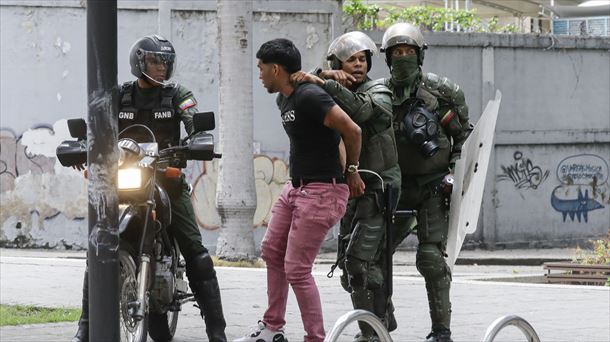 Una persona detenida durante las protestas en Venezuela. Foto: EFE