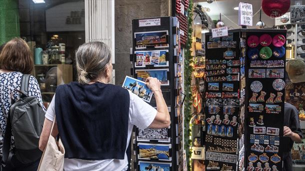 Turista batek postal bat begiztatzen du Bilbon
