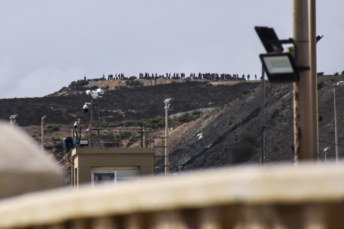 Decenas de personas se congregan en un monte cercano a la frontera con Ceuta. EFE.