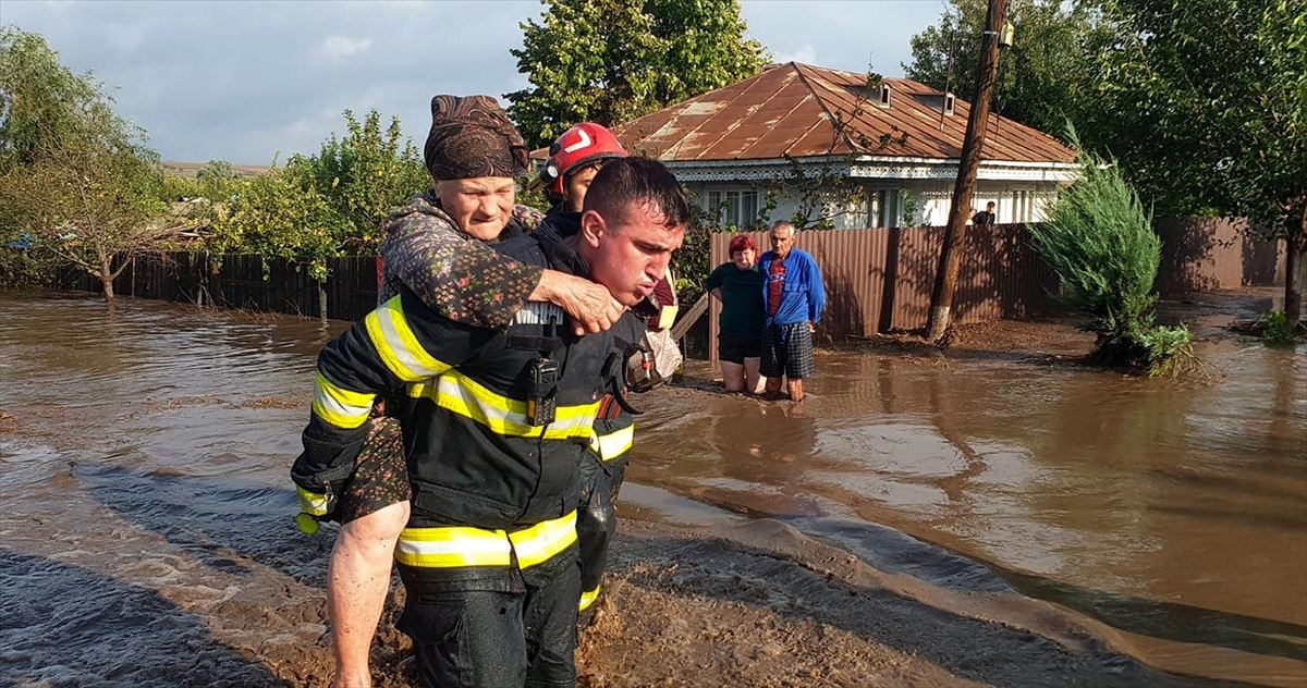 Un bombero evacua a una anciana en Rumanía. EFE. 