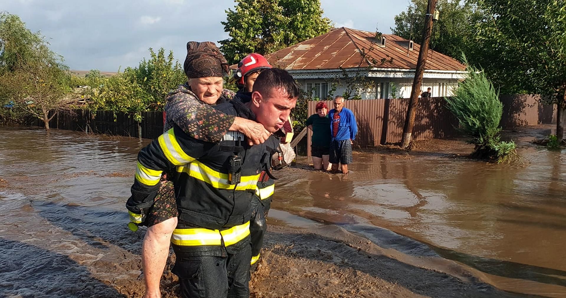 Un bombero evacua a una anciana en Rumanía. EFE. 