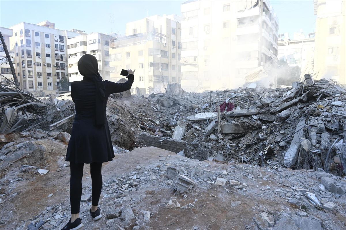 Una mujer fotografía las ruinas del edificio bombardeado por Israel en Beirut. Foto: EFE