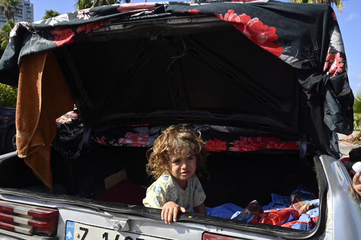 Un niño desplazado duerme en el maletero de un coche en Beirut. 