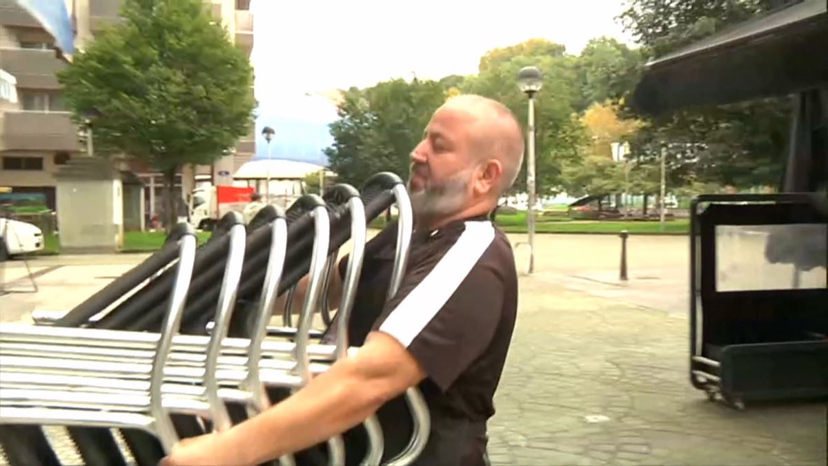 Camarero recogiendo la terraza. Imagen obtenida de un vídeo de EITB Media.