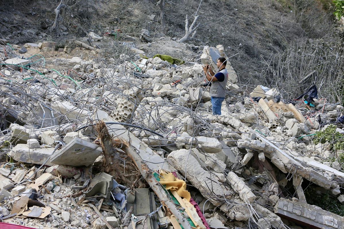 Un hombre sacando una foto a los destrozos provocados por un ataque en el Líbano