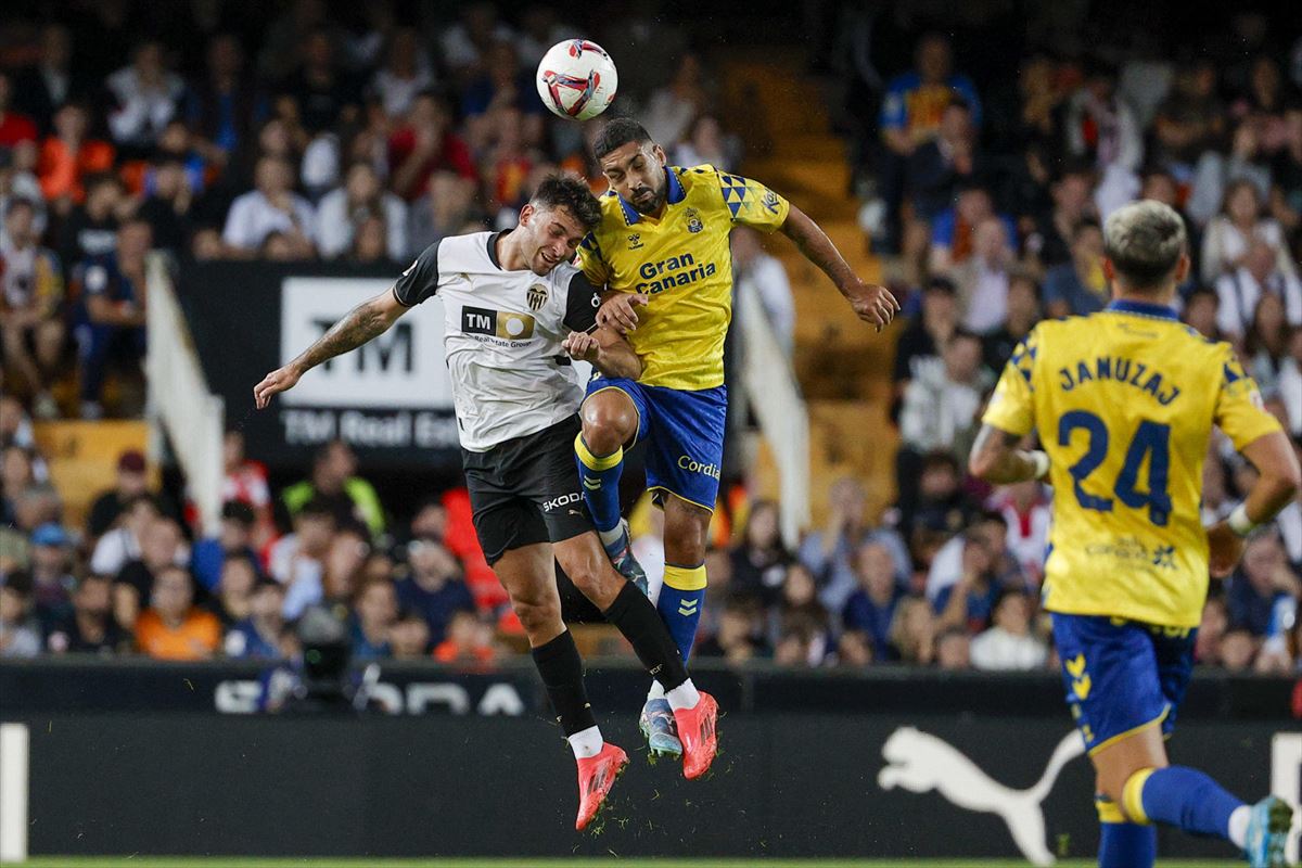 Dos jugadores de Valencia y Las Palmas disputan un balón aéreo ayer, en Mestalla. Foto: EFE