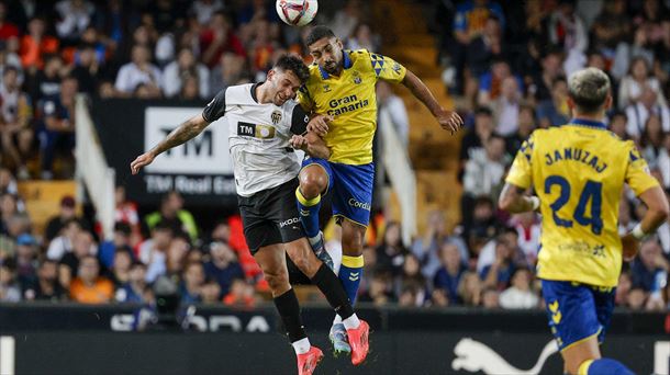 Dos jugadores de Valencia y Las Palmas disputan un balón aéreo ayer, en Mestalla. Foto: EFE