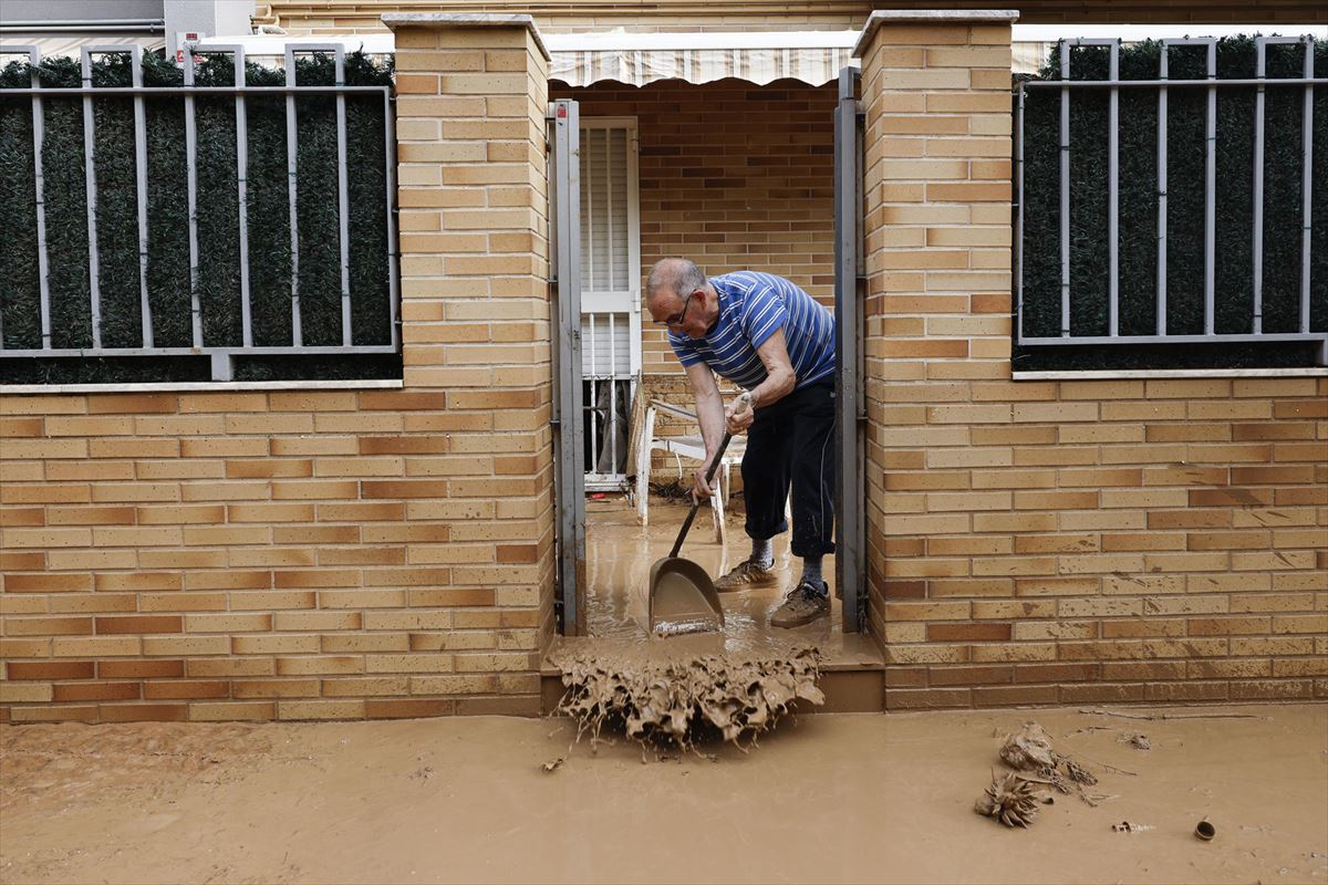 Un hombre retira el lodo acumulado por las intensas lluvias en Picaña