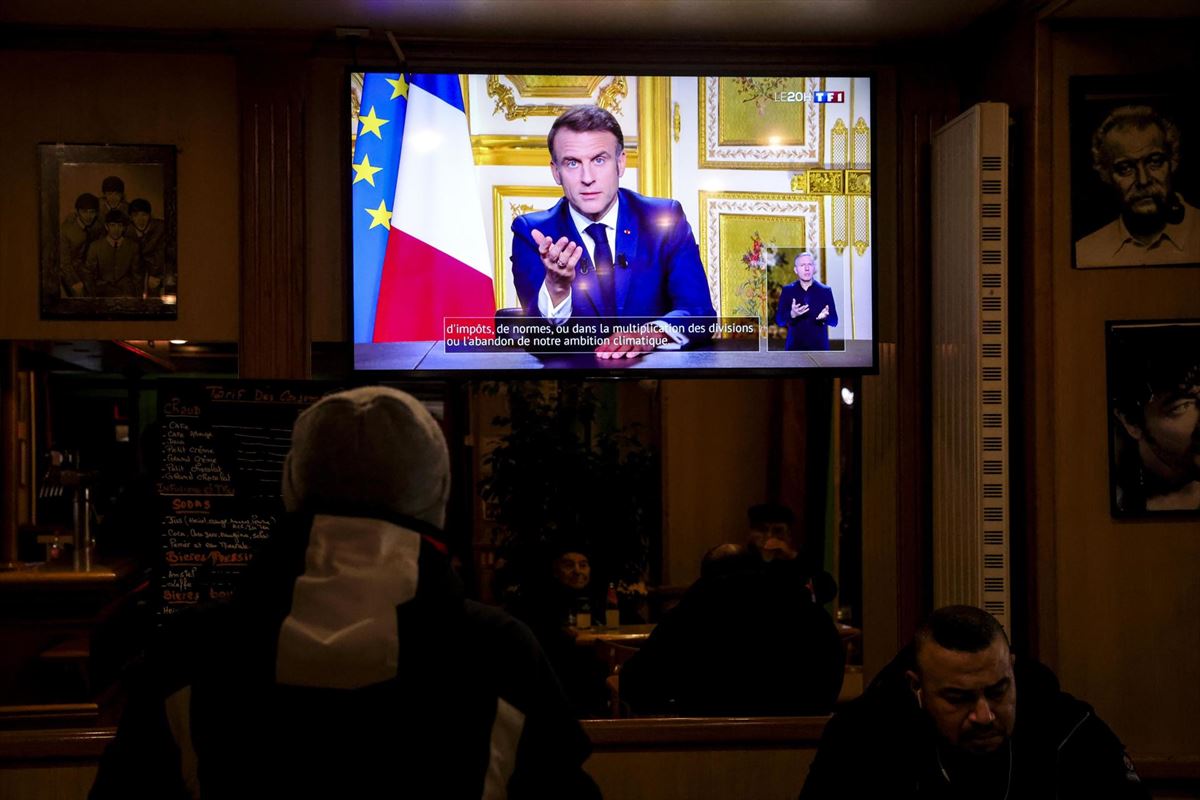 El discurso televisado de Macron en una televisión de una cafetería de París. Foto: EFE