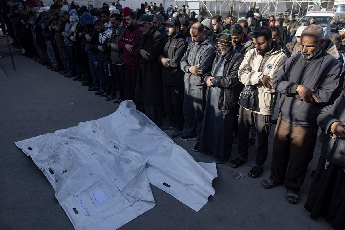 Desplazados palestinos rezan ante los cuerpos de víctimas hoy en Khan Yunis (Gaza). Foto: EFE