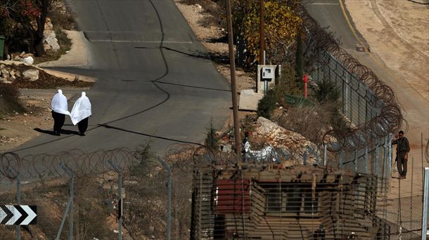 Emakume druzuak Israelgo soldaduen aurretik pasatzen Golango Gainetan. Argazkia: EFE