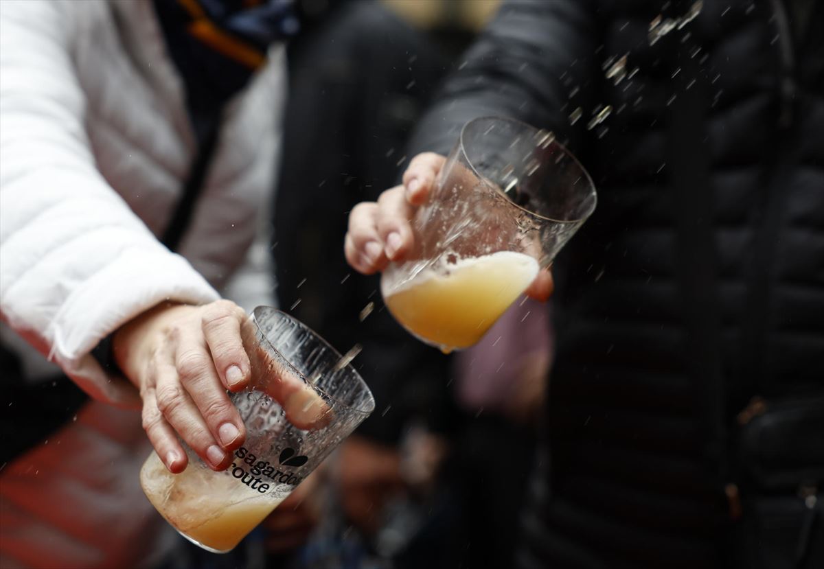 Varias personas escancian vasos de sidra en la presentación de la temporada de 'txotx' 2025