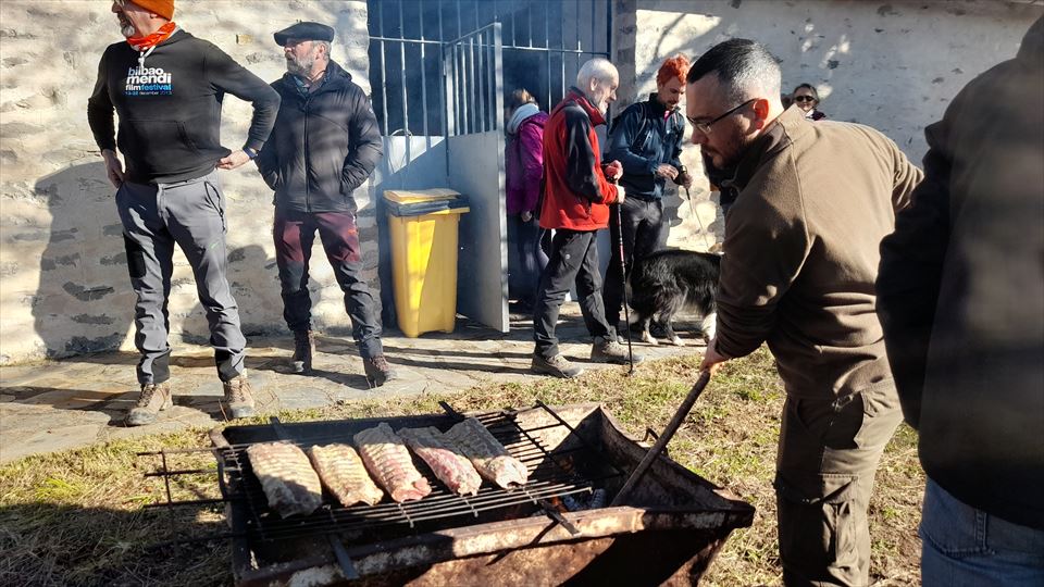 Mientras, en el exterior otros vecinos preparan la costilla asada para el almuerzo